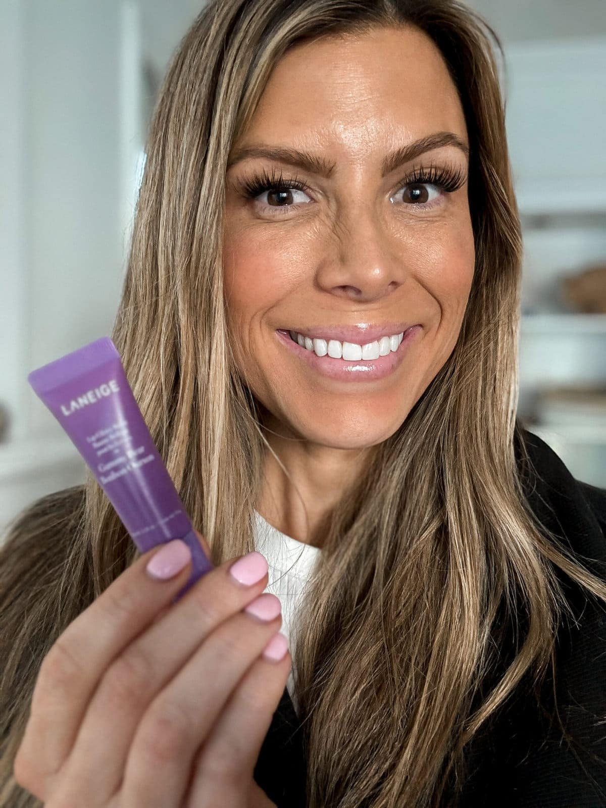 Corrine holding a Laneige Glowy Lip balm